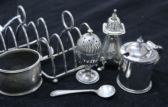 A group of small silver including two toastracks, a pepper pot, a napkin ring and two plated cruets.
